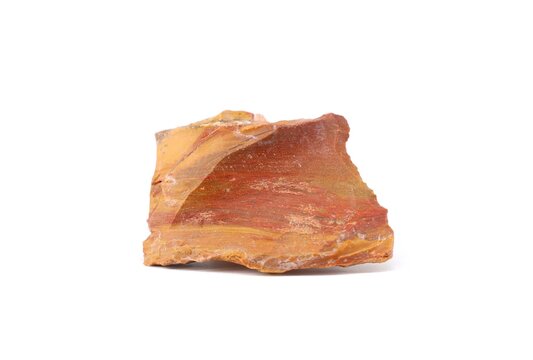 Raw polychrome jasper gemstone on white background. Colors are red, dark yellow and beige.