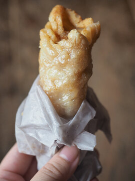 hand holding Thai sweet crispy roti wrap with sugar and condensed milk