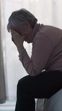 Sad, stress and senior woman in home, anxiety and mourning for grief, loss and contemplation. Remember, tired and person with depression, mental health or retirement with reaction and alzheimer