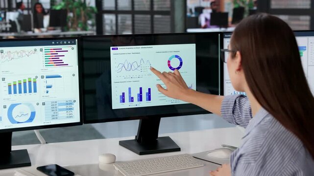 Data Analyst Studies Multiple Dashboards On Computer Screen