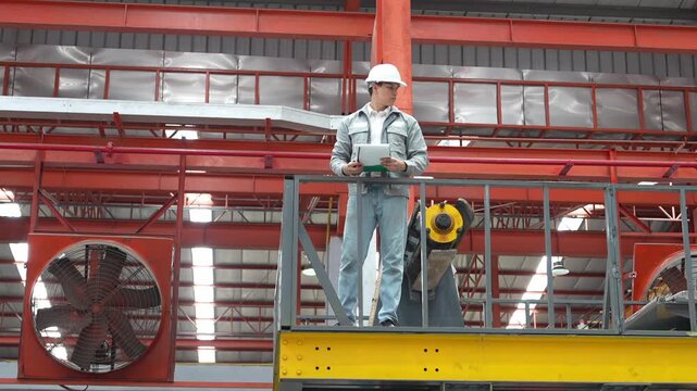 Industrial worker overseeing machinery operation factory photograph interior high angle safety and efficiency insights