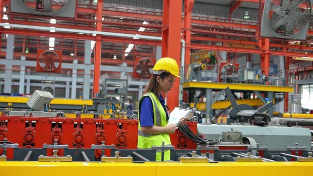 Industrial worker checking equipment in factory manufacturing plant operational process indoor environment close-up view efficiency evaluation