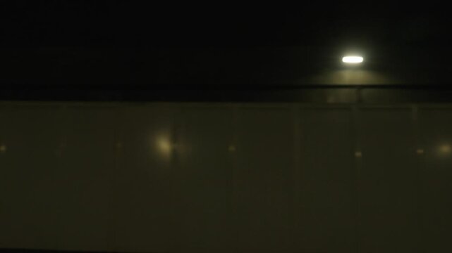 Close view of tunnel lights and reflective wall with motion blur night driving background
