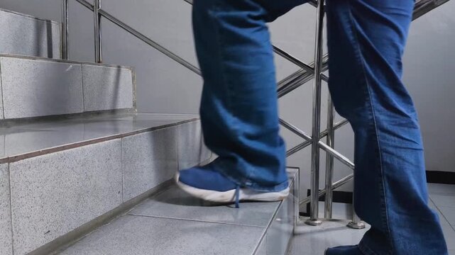 Side view of a person climbing up indoor stairs