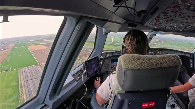 Pilot cockpit landing on Schiphol runway over shoulder view