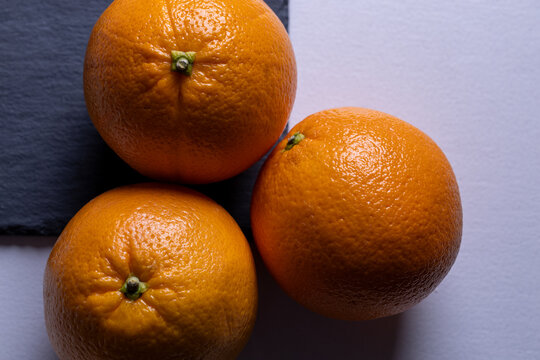 Fresh oranges arranged on a table in top view. Healthy citrus fruit, natural light and minimal composition ideal for nutrition and food concepts.