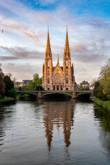 Obraz premium Cathedral Spires Glowing Above Canal at Dusk Couple Walk