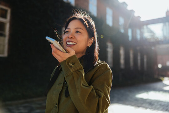 Young woman speaking into phone outdoors on city street