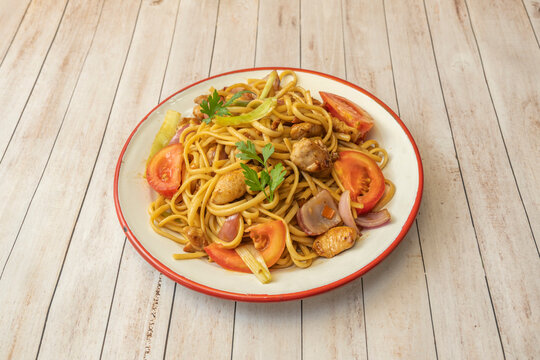 Peruvian stir-fried noodles with juicy beef, thick noodles stir-fried in a wok with onion, tomato, red and yellow bell peppers
