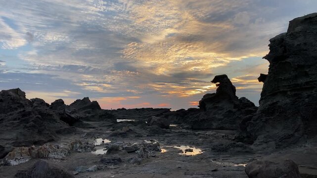 4K Horizontal cinematic sunset at Godzilla Rock in Akita, Japan, silhouette of iconic rock formation against golden sky