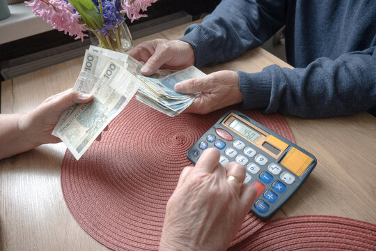 A retired couple counts money in Polish zlotys and establishes a household budget.
