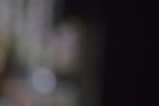 Abstract dark and muted bokeh background. Soft, out-of-focus highlights with neutral blur.