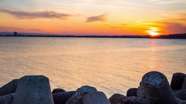 Breakwater against the background of a cloudy sky and the Black Sea with waves