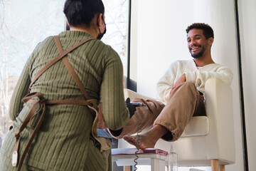 Fototapeta premium Adult man receiving pedicure grooming treatment at beauty salon