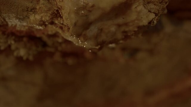 Static shot up close to dripping water from a cave ceiling.