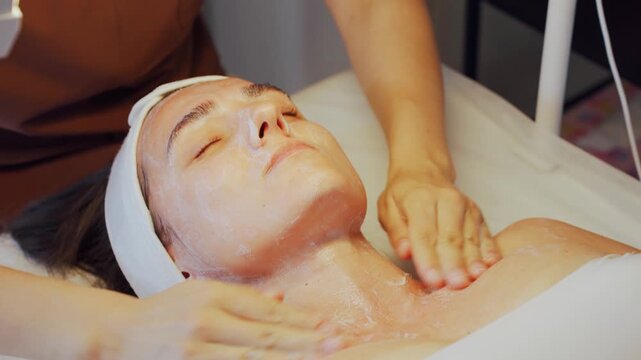 Beauty care routine. Skincare professional thoroughly performs facial cleansing and relaxing massage. Skincare expert diligently carries out facial cleaning followed by soothing massage session