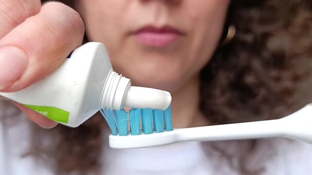 The process of applying toothpaste to a toothbrush