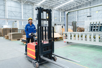 African man operates a forklift in a busy warehouse, inspecting cardboard boxes and machinery while wearing a yellow shirt and dark pants, focused on logistics and safety procedures. © AU USAnakul