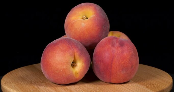 Close-up footage of peach fruit on black background.