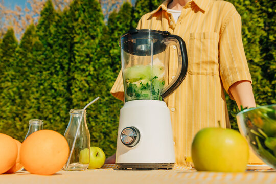 Preparing fresh fruit and vegetable blend outdoors in spring