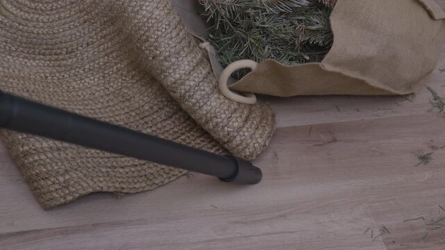 Vacuum cleaning pine needles from carpet after Christmas tree.Post-holiday cleaning, home maintenance, mess removal and everyday domestic routine. Real life cleaning situation, seasonal transition
