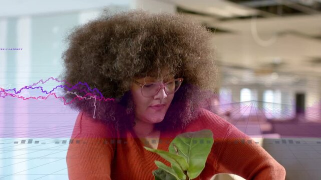 Woman reaching into box placing plant in pink pot at office, personalizing desk, charts overlaying