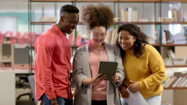Three office team leaning around tablet, center person tapping, sharing while red graphics sweeping