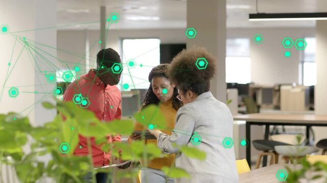 Right-side woman pointing tablet, team leaning in viewing business data with shifting green overlay