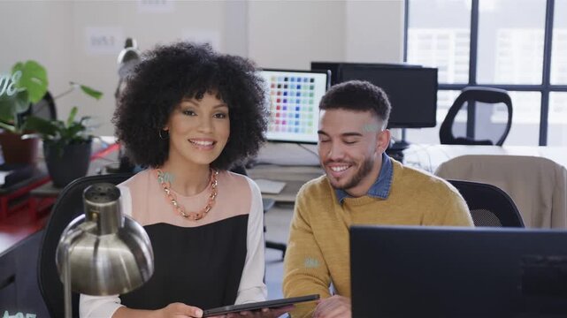 Woman tapping tablet and man leaning in, activating analytics overlay and addressing camera