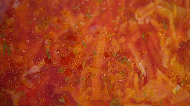 Rich and flavorful borscht filled with fresh ingredients and spices. Steaming pot of traditional beet soup with cabbage carrots potatoes and herbs visible