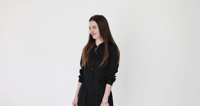 Young woman in black dress shakes head in refusal. Long-haired female covers nose with hand clearly expressing strong sense of disgust. Slow motion
