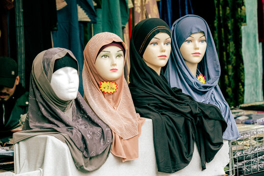 Mannequin Heads Displaying Hijabs for Sale at Outdoor Market Stall, Bologna, Emilia-Romagna, Italy
