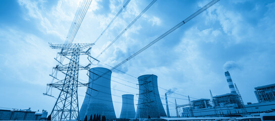 Large Steel Transmission Tower with Multiple Cooling Towers and Power Plant Under Blue Sky