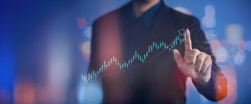 Professional investor pointing to a bullish stock market trend on a futuristic holographic dashboard. Investment growth and wealth management and analysys concept.