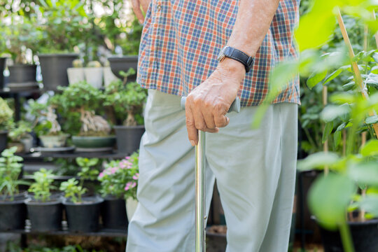 Shot of mature man with walking stick standing in the garden at home