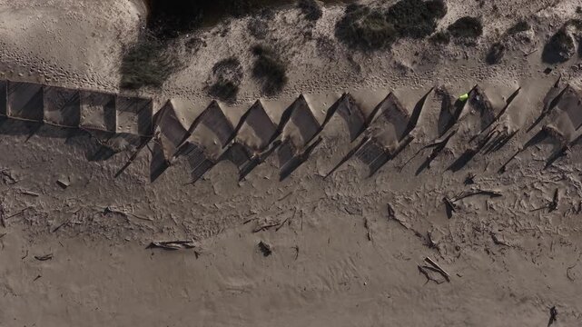 Partially destroyed wood barriers for coastal erosion prevention on the sand dunes in Portugal.