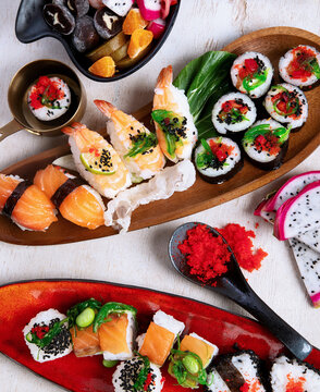 A table with Asian food, sushi, rolls, desserts.