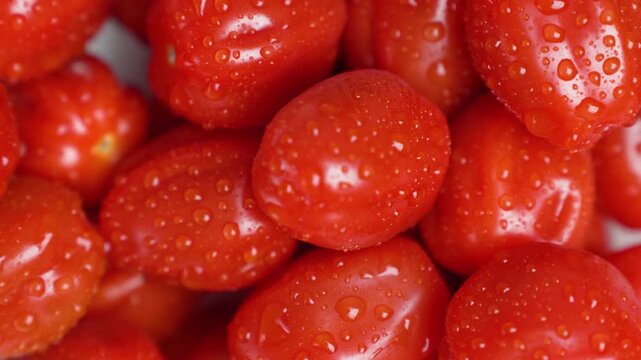 Detailed macro shot of fresh cherry tomatoes with water droplets highlighting texture and freshness. Organic food, healthy eating, natural ingredients, and farm produce concept.