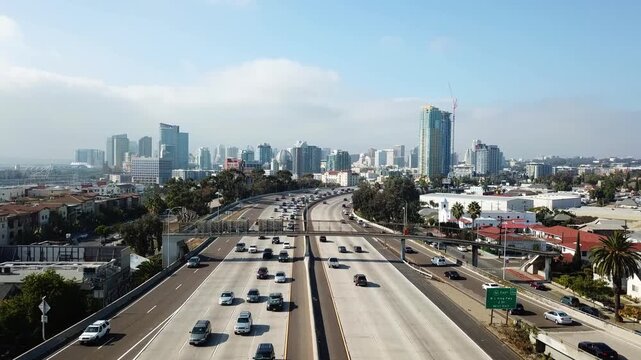Drone flying forward at 3PM toward downtown San Diego with a dancing subject on a bridge and skyline in the background.