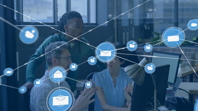 Team consulting monitor at desk envelope appearing icons overlaying staff showing business network