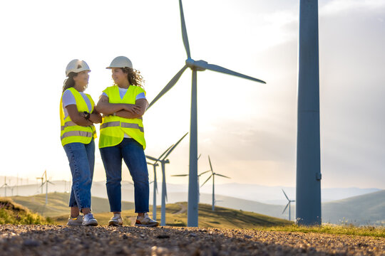 Engineers discussing clean energy generation at a wind turbine farm