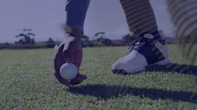 Golfer picking up, placing golf ball on tee, preparing shot while dotted overlay moving across shoe