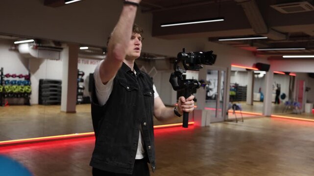 Videographer suddenly reacts trying to protect camera from impact during filming showing unexpected moment of risk and tension while handling equipment in indoor studio environment