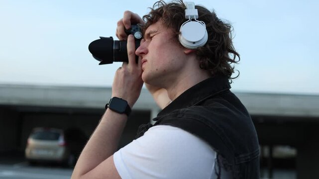 Young photographer holds camera close to eye and takes photo focused on composition and moment hobby photography creative vision urban lifestyle concentration and precision