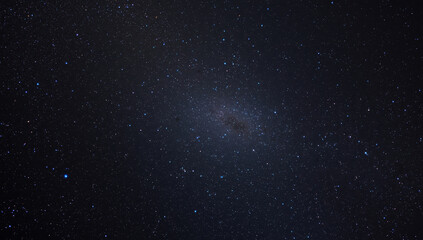 Fototapeta premium Star filled deep space with distant galaxy and soft glowing nebulae, serene night sky