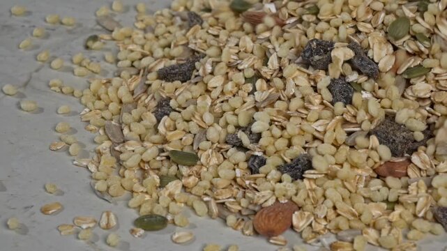 Granola mix food items sliding across a patterned marble stone surface texture