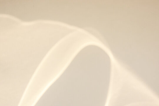 Abstract caustic light refraction on beige wall texture background