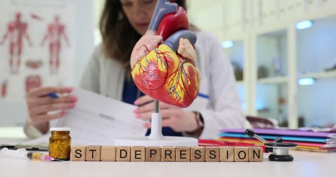 Wooden blocks spell phrase ST Depression near heart model and medicine jar. Doctor reviews report checking therapy notes while updating treatment plan
