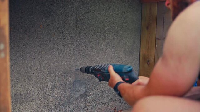 Man Using Power Drill To Drill Into A Surface - Close Up
