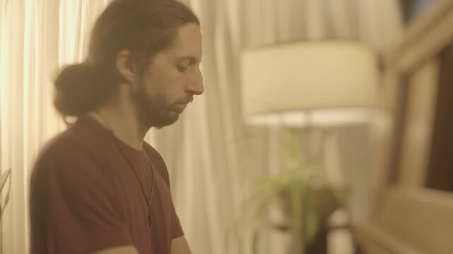 A Man Plays the Piano With Focused Concentration, His Hands Moving Gently Over the Keys as Soft Light Filters Through the Room - Defocused Shot